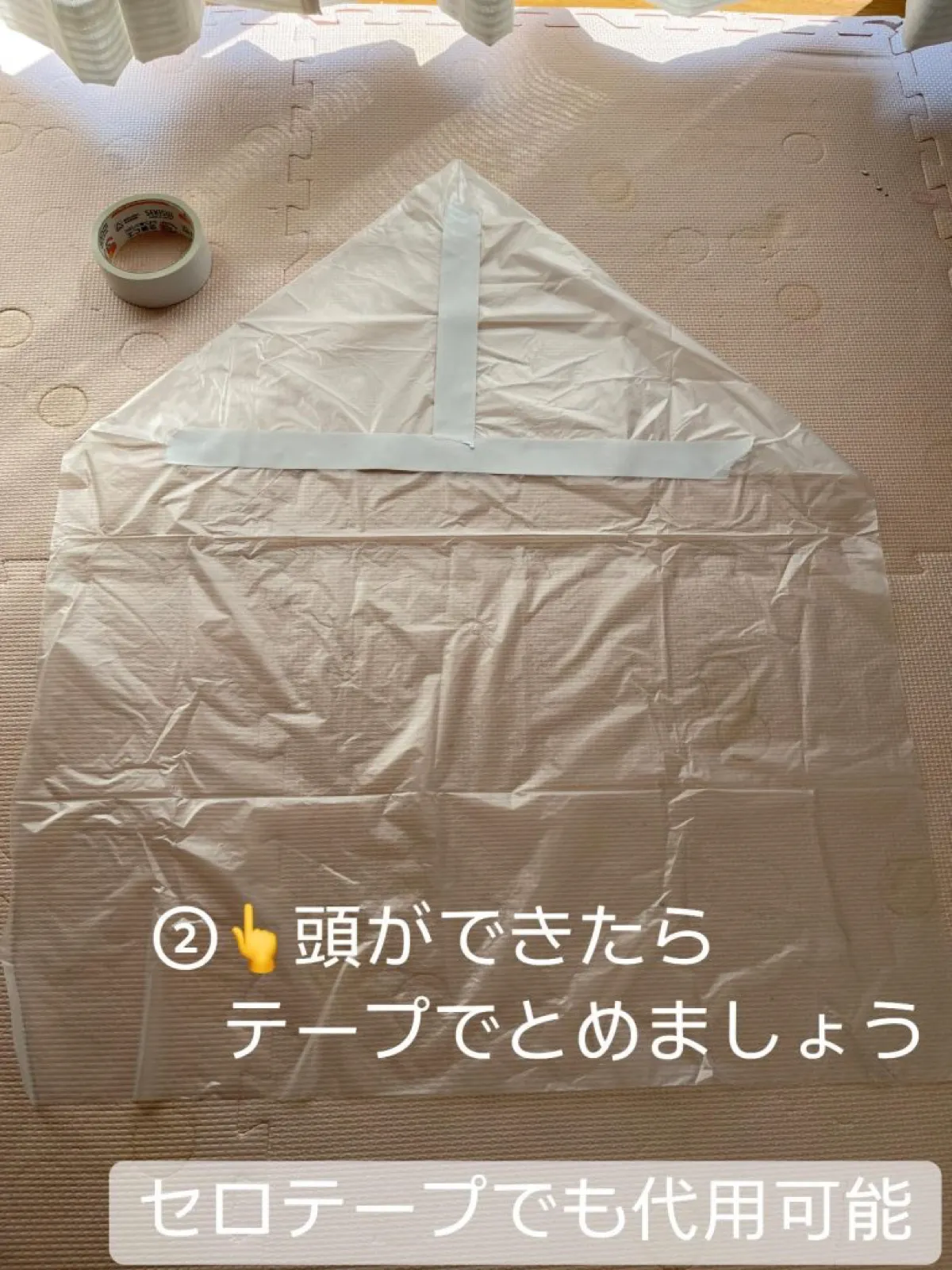 折ったすみをテープで留め、ゴミ袋の上側がとがったイカの頭の形になっている。