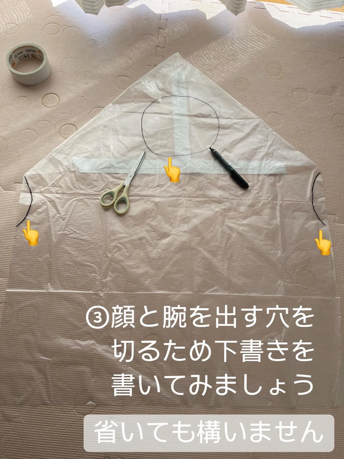 顔と腕を出す穴の位置に、ペンで丸と弧の下書きがしてあるゴミ袋。