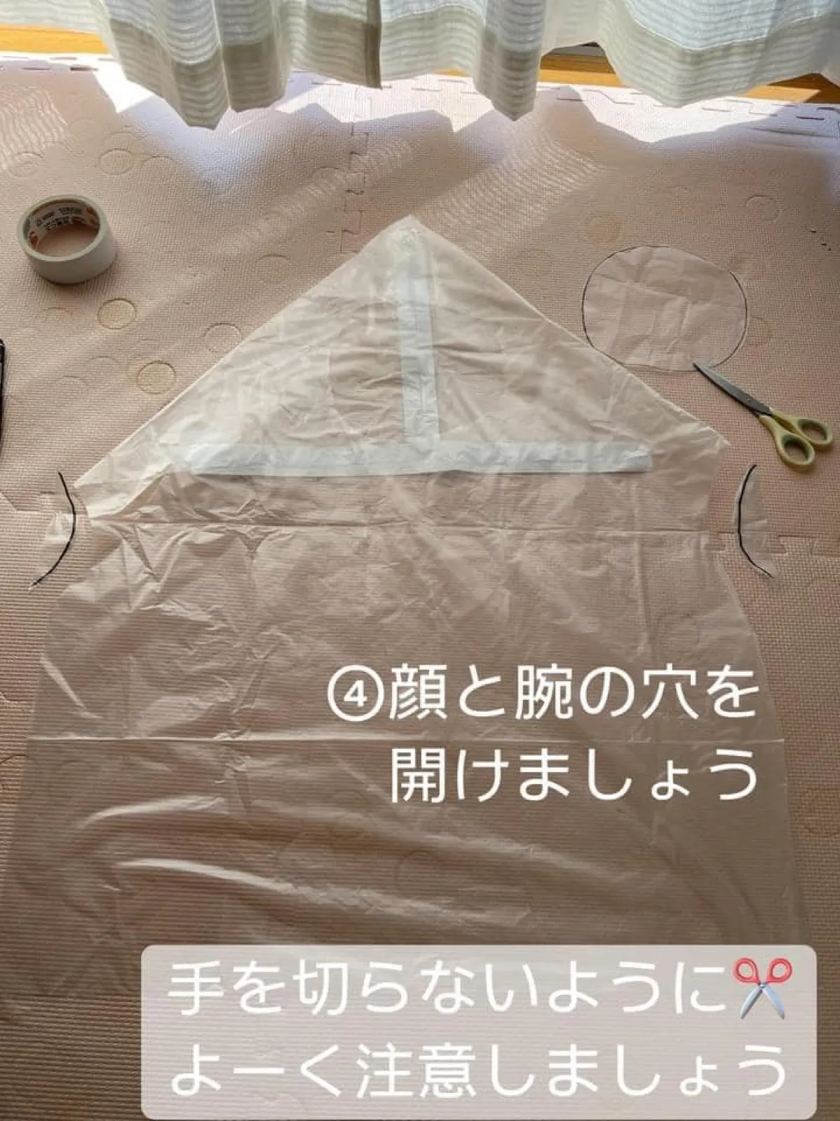 顔の丸い穴を切り抜き、左右の腕の穴にもハサミを入れたゴミ袋。