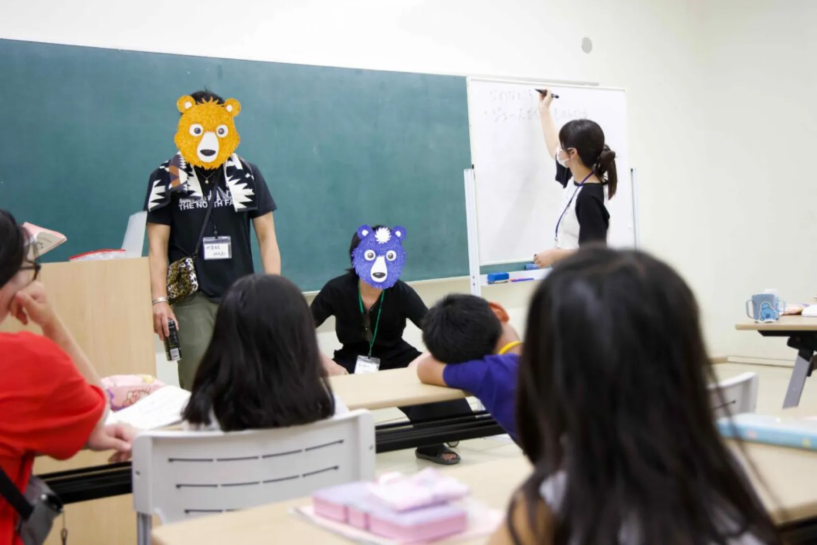 学習会で、ホワイトボードに文字を書くスタッフの前に、子どもたちが座っている。
